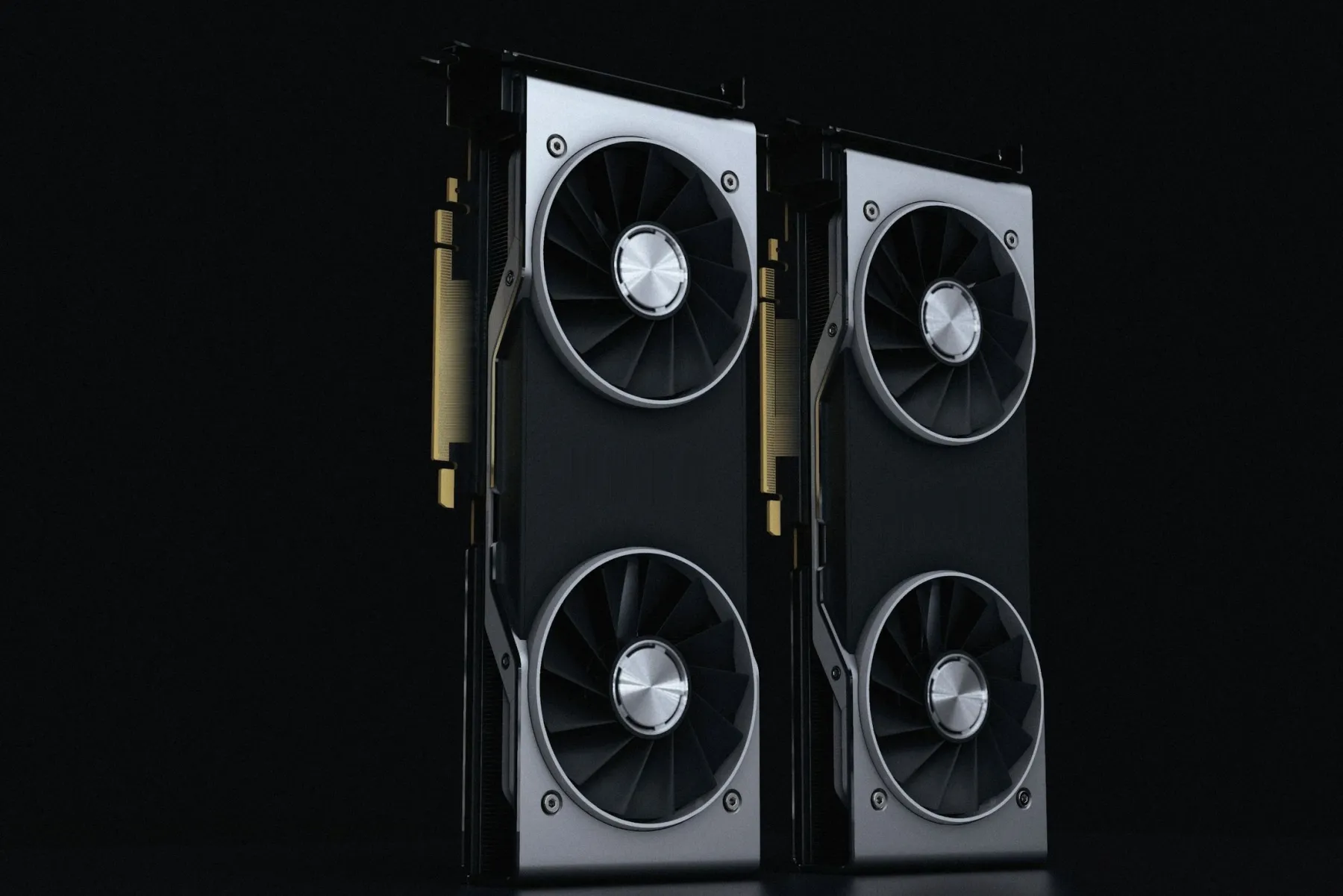 Two graphics cards standing upright on a dark studio floor, lit from above.